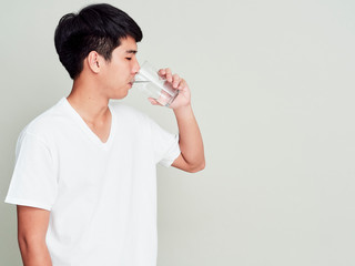 Young man drinking water of glass.
