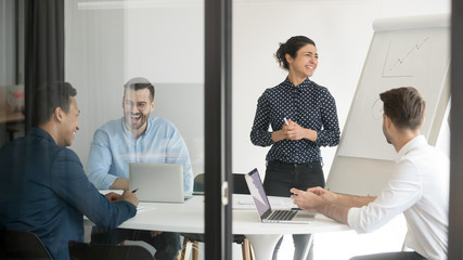 Happy indian speaker and team laughing during flip chart presentation