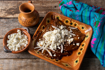 Mexican mole sauce enchiladas with cheese and sesame seeds