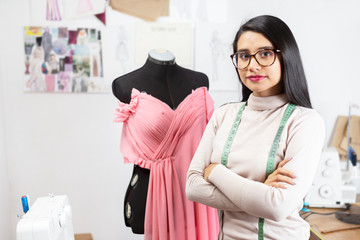 Portrait of a Hispanic fashion designer in her studio with her arms crossed- businesswoman