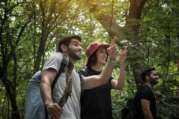 Travel and friendship concept. The man who heads the group shows the road with his hand.