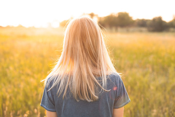 Young woman with blonde hair looking on the sunset