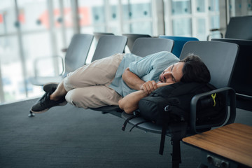 The guy at the airport is waiting for departure, asleep