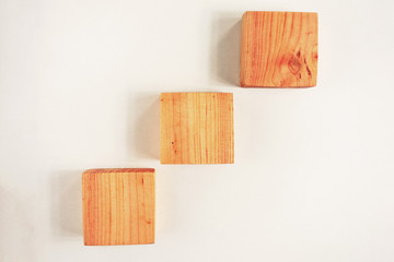 Wood square bar pieces with shadows on white background. Climbing wooden squares as concept of kids development toy, construction or decoration. Mockup stairs or diagram elements