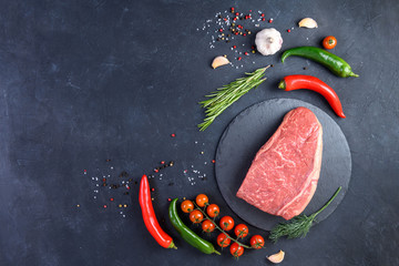 Raw fresh marbled meat and seasonings on dark background top view