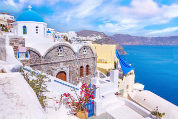 Beautiful Oia town on Santorini island, Greece. Traditional white architecture  and greek orthodox churches with blue domes over the Caldera, Aegean sea.