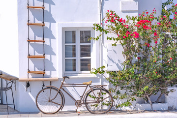 Fototapeta na wymiar Vintage bicycle in picturesque streets of Oia village on Santorini Island with traditional white architecture, Greece.