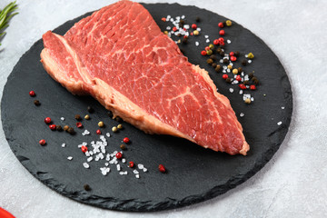 Raw fresh marbled meat and seasonings on grey background
