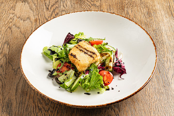 salad with fish on the wooden background