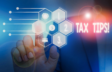 Writing note showing Tax Tips. Business concept for compulsory contribution to state revenue levied by government Male wear formal suit presenting presentation smart device
