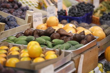 Viel frisches Obst und Gemüse wie Avocado, Orangen, Trauben auf einem Markt als Close up