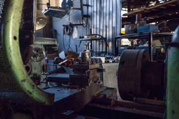 Rusty mechanisms and tools in the shop of an old abandoned factory.