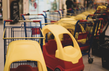 Carts in which it is possible to place children. Ease of shopping for the family. Modern solutions in trade. Game while shopping