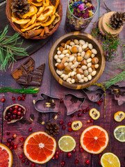 Ingredients for christmas baking spices, cookie cutters, green branch, dried apples, nuts, chocolate, fresh fruits