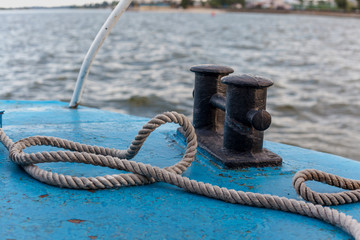 White rope and black bollard on bow of ship