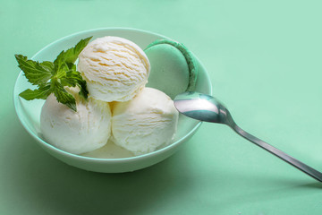 Balls of fresh ice cream with a sprig of mint and mint macaroon.