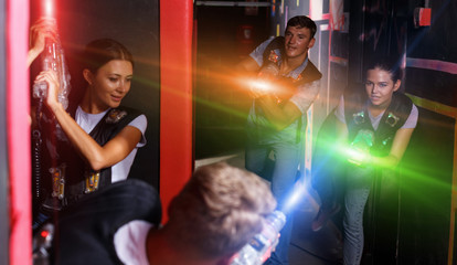 Obraz na płótnie Canvas Group of young people playing laser tag game with laser guns
