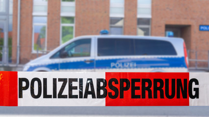 Polizeiabsperrung mit Polizeiwagen im Hintergrund