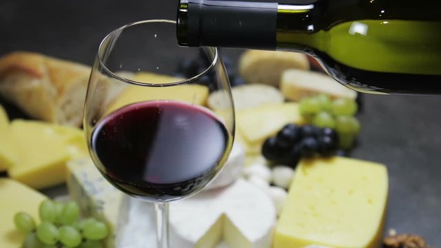 assorted cheeses, soft, hard, rennet and brine, and a glass of red wine.