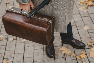 Close-up of carpetbag in  hand of intelligent man