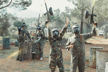 Fototapeta premium Cheerful young women in camouflage holding guns ready for playin