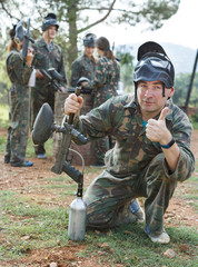 Paintball player in camouflage with gun