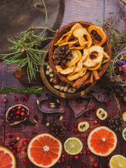 Holiday food background for baking cookies with cutters, spices, fruits, cranberries, nuts, dried apples, chocolate, raisin, on vintage table top view.