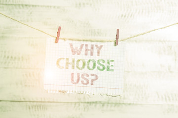 Writing note showing Why Choose Us Question. Business concept for Reasons for choosing our brand over others arguments Clothesline clothespin rectangle shaped paper reminder white wood desk