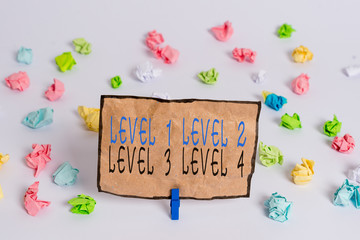 Text sign showing Level 1, 2, 3 and 4. Business photo text Steps levels of a process work flow Colored crumpled papers empty reminder white floor background clothespin