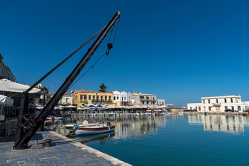Fototapeta premium Rethymno, Crete, Greece. September 2019. Small fishing boats on the historic old venetian harbour a popular tourist attraction in Rethymno, Crete.
