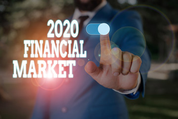 Text sign showing 2020 Financial Market. Business photo text place where trading of equities, bonds, currencies Male human wear formal work suit presenting presentation using smart device