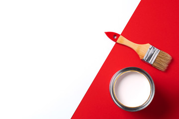 Wooden paint brush, open paint can on trendy red and white background. Top view, copy space....