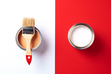 Wooden paint brush, open paint cans on trendy red and white background. Top view, copy space. Appartment renovation, repair, building and home design concept.