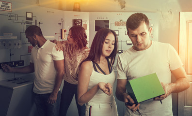 Girl and guy checking battery charger in escape room