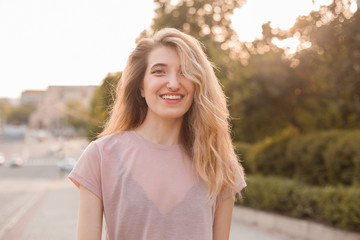 Fototapeta premium Portrait of happy beautiful young woman in the city under sunlight