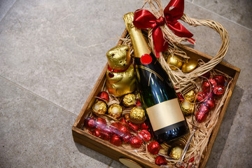 Bottle of champagne with candies and ornaments gift placed in wooden box © Vladimir
