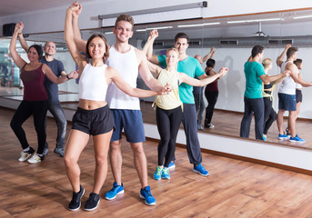 Group of smiling people dancing salsa together