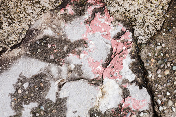 Naklejka premium cracked dirty stone wall with red, gray and dark gray pieces, concrete wall brocken and weathered with structure