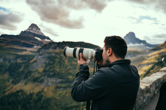 Man taking a photo of the Landscape at Logan Pass, Montana.