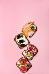 Trendy sandwiches with fresh fruits, like pomegranate, figs, mulberry and pears. Healthy food concept  with different sandwiches with vibrant color  style.