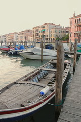 Fototapeta na wymiar Wooden boat near the pier, Venice, tether posts