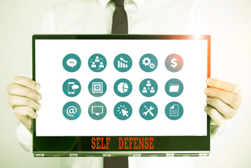Handwriting text Self Defense. Conceptual photo the act of defending one s is demonstrating when physically attacked Male human holding thick textured cardboard of business promotion concept