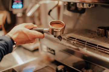Barista make coffee latte art with espresso machine in cafe vintage instagram filter. Barista male hands make fresh flavored coffee close-up. Vintage coffee machine and hands professional barista. 
