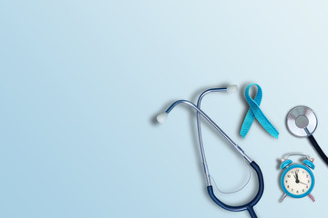 blue lung cancer awareness ribbon with stethoscope and copy space on blue background. November lung cancer awareness month. Healthcare and medicine concept.