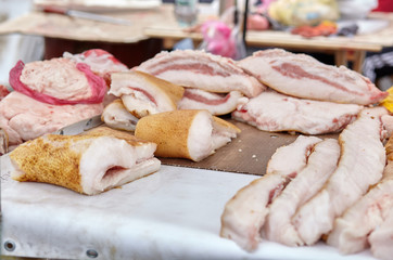 Large pieces of fresh lard lie on the counter.Bacon and lard on street market or farm market