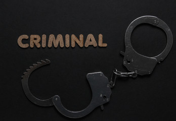 Steel handcuffs on black background. Criminal, corruption concept