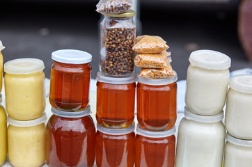 Different varieties of sweet golden and white honey at the farmers market. Natural honey in various jars.Vitamin healthy food