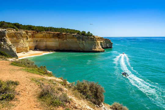 Scenic landscape of Praia da Corredoura enclosed by imposing sandstone cliffs, Agarve, Portugal