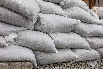 Stack of nylon bags with stones. Pebble bags fortification wall. Winter storm and flood defense...
