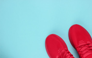 Stylish men's red sports shoes for running on blue background. Top view. Copy space